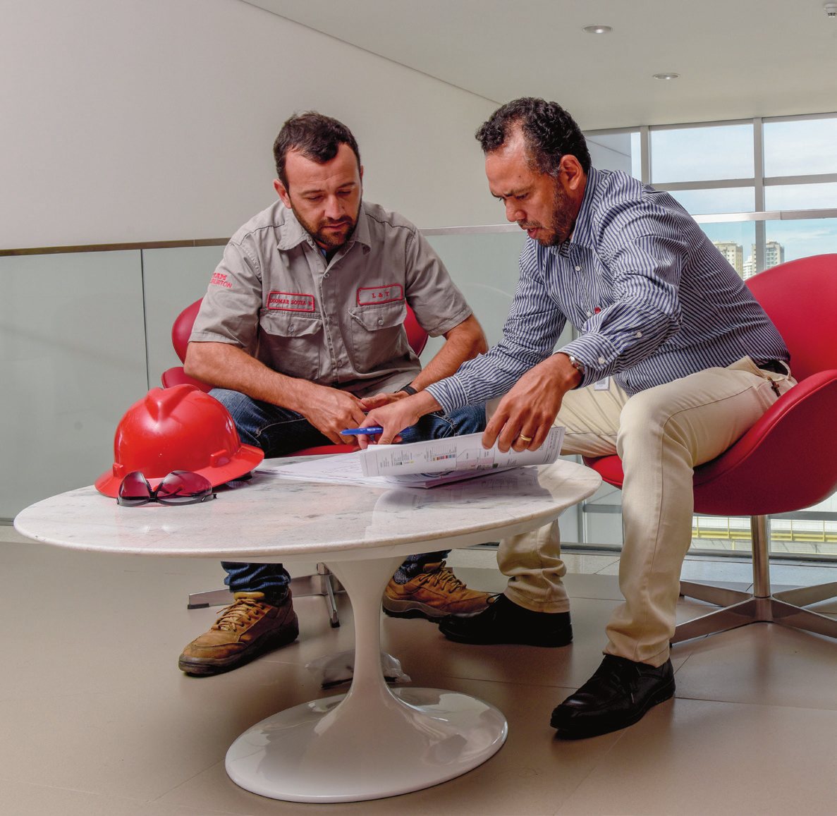 Two colleagues reviewing plans at a marble table